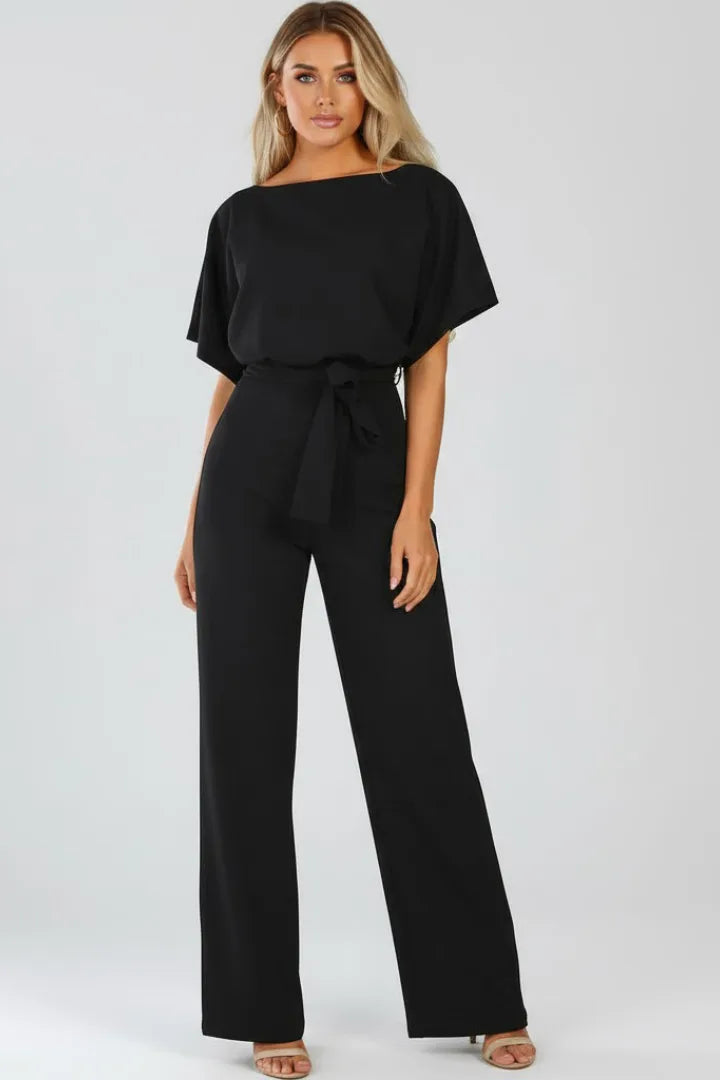 Front view of a black jumpsuit with loose kimono sleeves, tie belt and wide flowing trouser legs