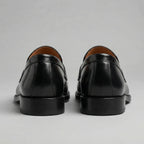 Rear view of both loafers showing the heel seam and tan interior lining