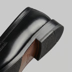 Close-up of the heel and sole edge showing the rubber tread and stitched leather welt