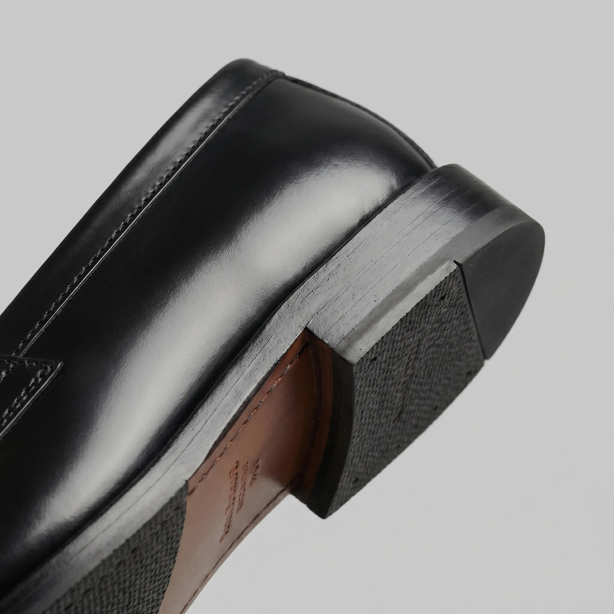 Close-up of the heel and sole edge showing the rubber tread and stitched leather welt