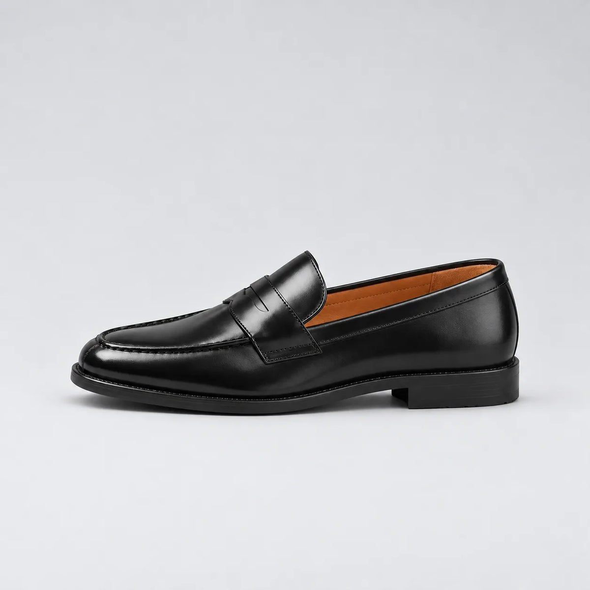 Clean side profile of the black penny loafer against a plain studio background