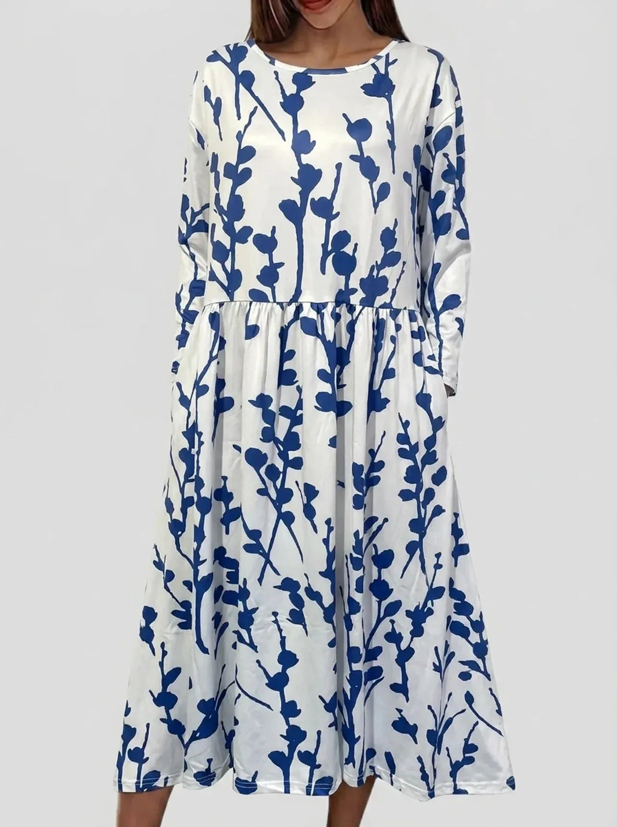 Front view of white midi dress with navy blue botanical branch print, long sleeves and round neckline
