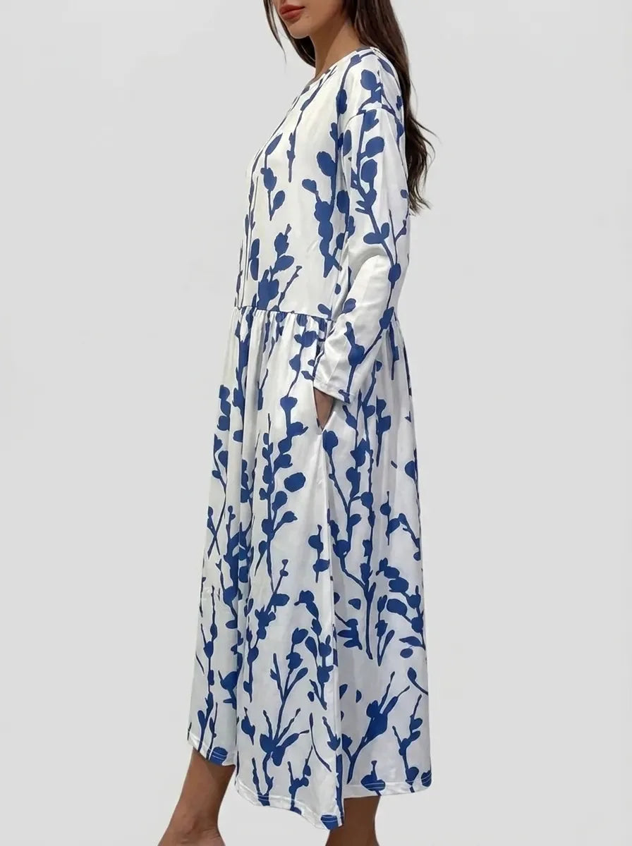 Side profile showing the relaxed A-line silhouette and flowing skirt of the navy branch print midi dress