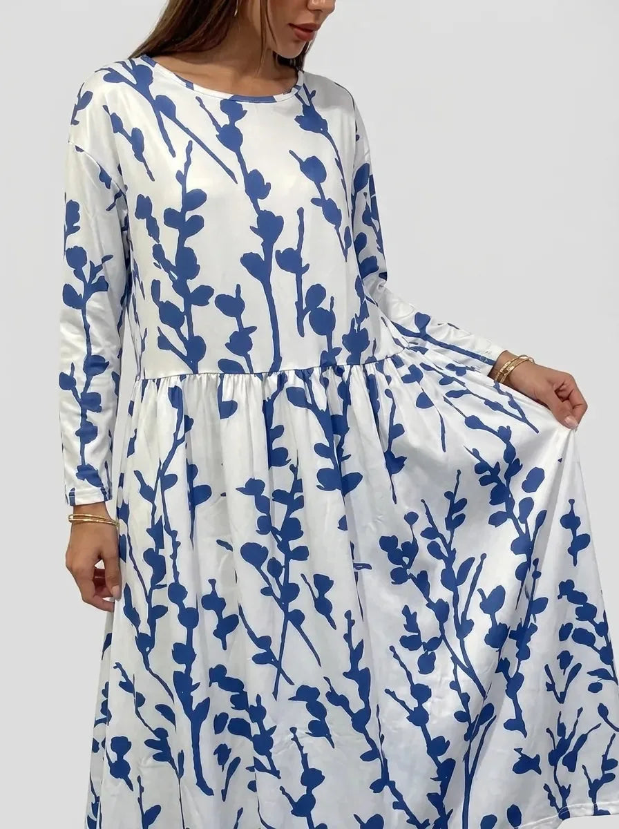 Close-up of model holding the skirt, showing the soft drape and navy leaf and stem pattern on white fabric