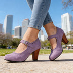 Lavender suede Mary Jane pumps with perforated trim and stacked wooden heel, worn with jeans outdoors