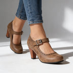 Brown Mary Jane pumps shown mid-stride, highlighting the curved topline and block heel on a studio background
