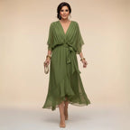 Woman modelling a green chiffon midi dress with V-neck, draped sleeves and tied waist belt