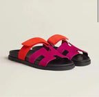 Colour-block slide sandals in orange and magenta suede-look straps with a black chunky sole.