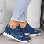 Side angle of olive green sneakers showing the diamante toe panel and cushioned white midsole on a wooden floor
