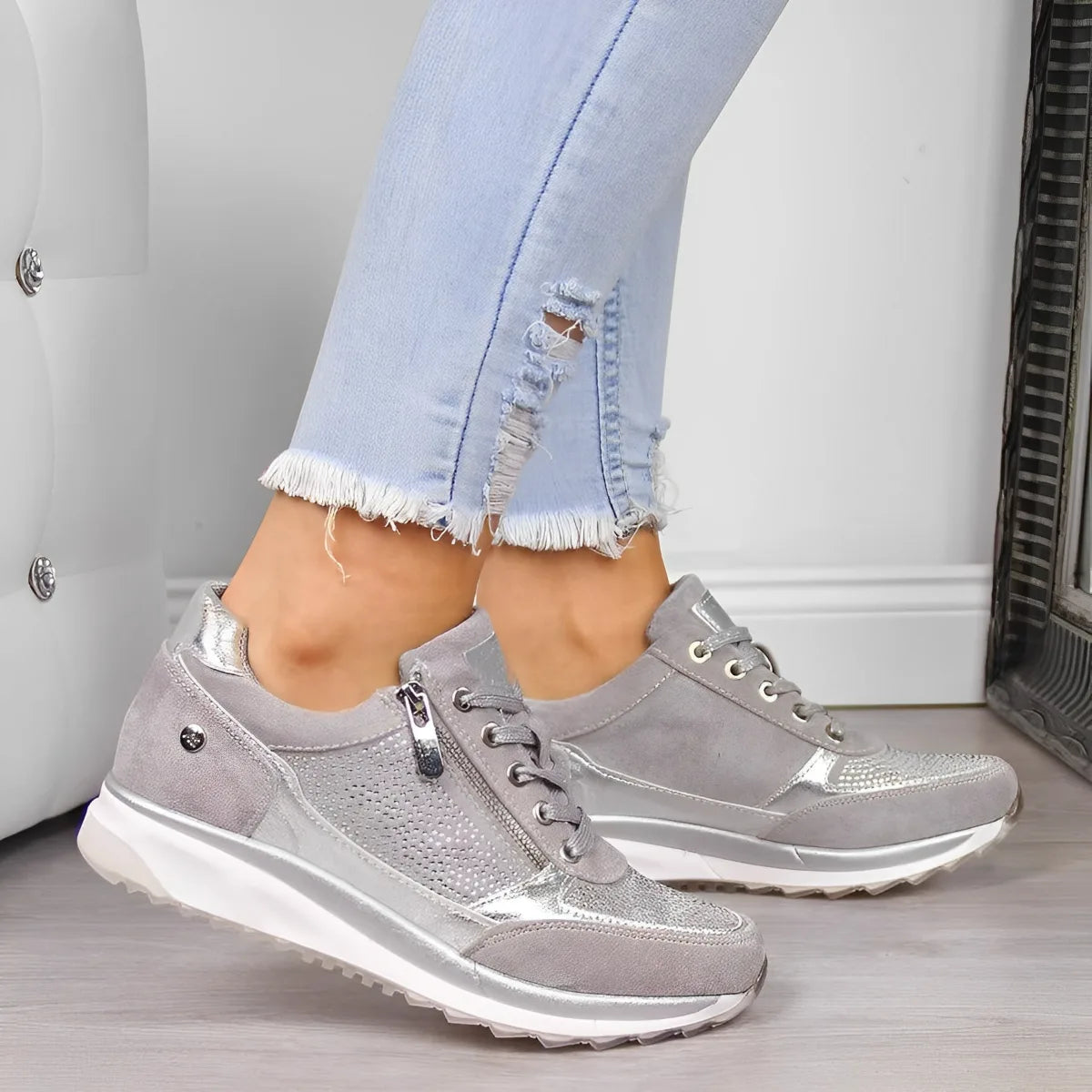 Overhead flat lay of grey suede and silver sneakers paired with sunglasses and a wristwatch