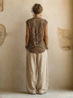 Back view showing the symmetrical paisley print across the sleeveless top and the flowing beige wide-leg pants