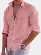 Close-up front view of a man in a pink cotton linen shirt, unbuttoned collar, with a chain necklace and watch