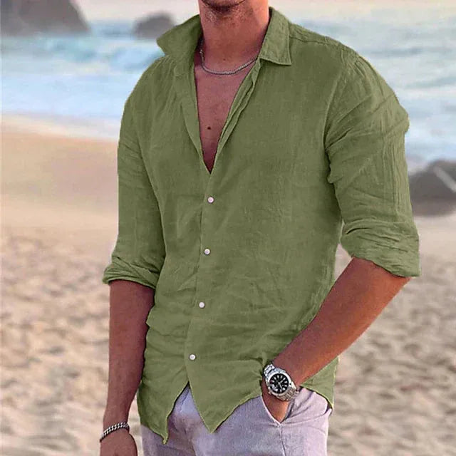 Olive green linen shirt with classic collar, shown half-buttoned on a model standing by the shore