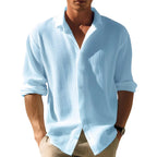 Model wearing the shirt in pale blue, open-collar with sleeves rolled, styled with beige pants