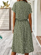 Rear view of the olive green dotted midi dress showing the flowing skirt and elasticated waistband