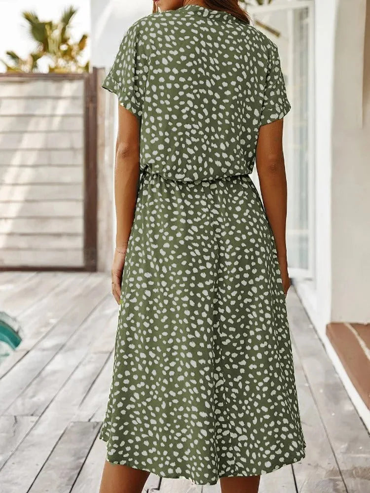 Rear view of the olive green dotted midi dress showing the flowing skirt and elasticated waistband