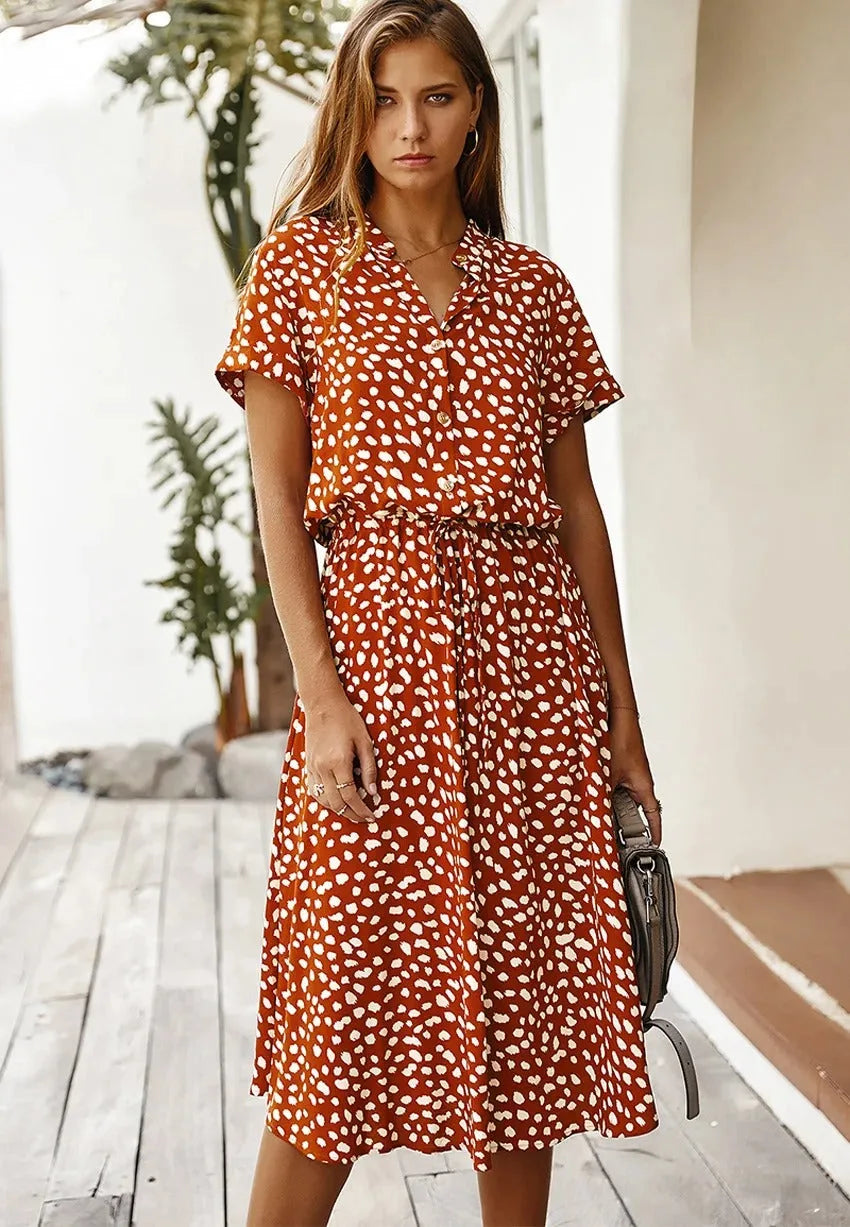 Front view of the rust orange dotted midi dress with collar, button placket and short sleeves