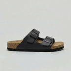 Side view of a black double-strap buckle sandal with matte strap finish and black outsole