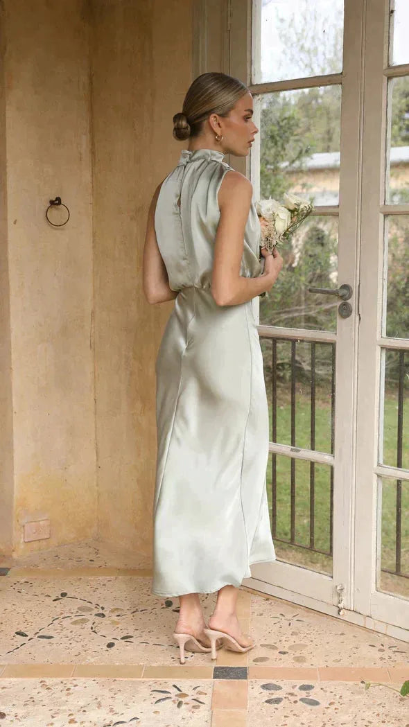 Back view of sage green satin dress showing high ruffled collar and open back detail