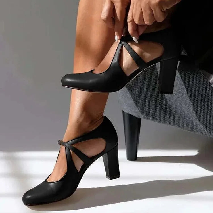 Black leather strap heels with round toe, crossover ankle strap and chunky block heel, shown in profile.