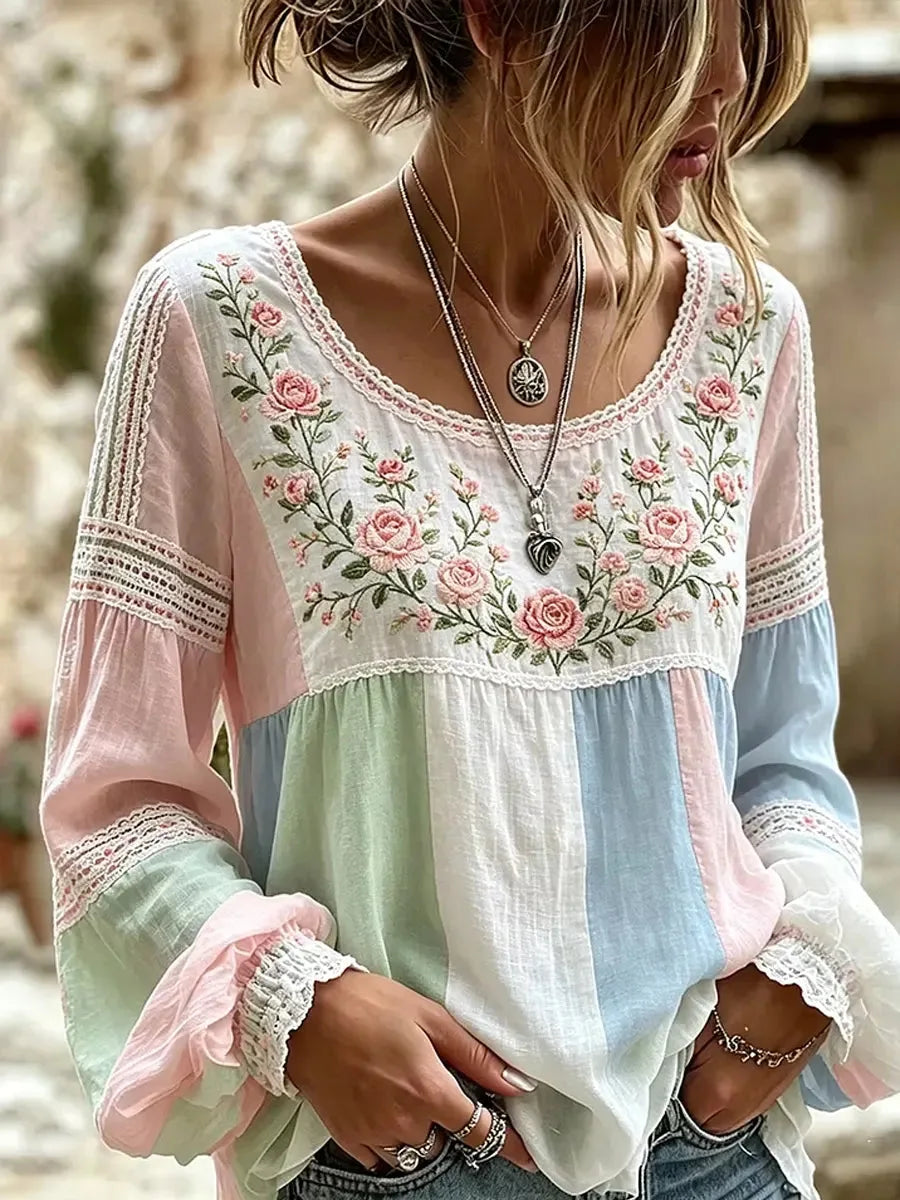 Close-up of pastel colour-block blouse with pink, blue and green panels and pink rose embroidery across the neckline