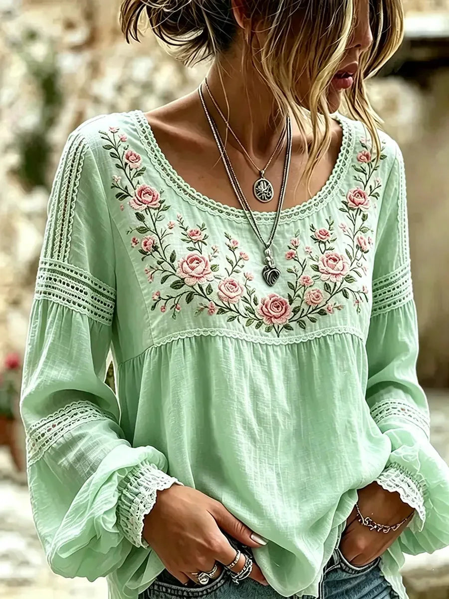 Mint green blouse with crochet lace sleeve inserts and pink floral embroidery below a scoop neckline