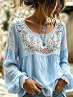 Pale blue blouse featuring ruffled lace cuffs and a hand-embroidered pink rose motif at the chest