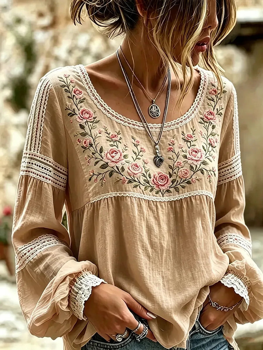 Khaki beige blouse with lace-trimmed bishop sleeves and floral embroidery framing the round neckline