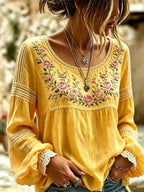 Yellow blouse with crochet lace detailing on the sleeves and an embroidered pink rose bouquet design