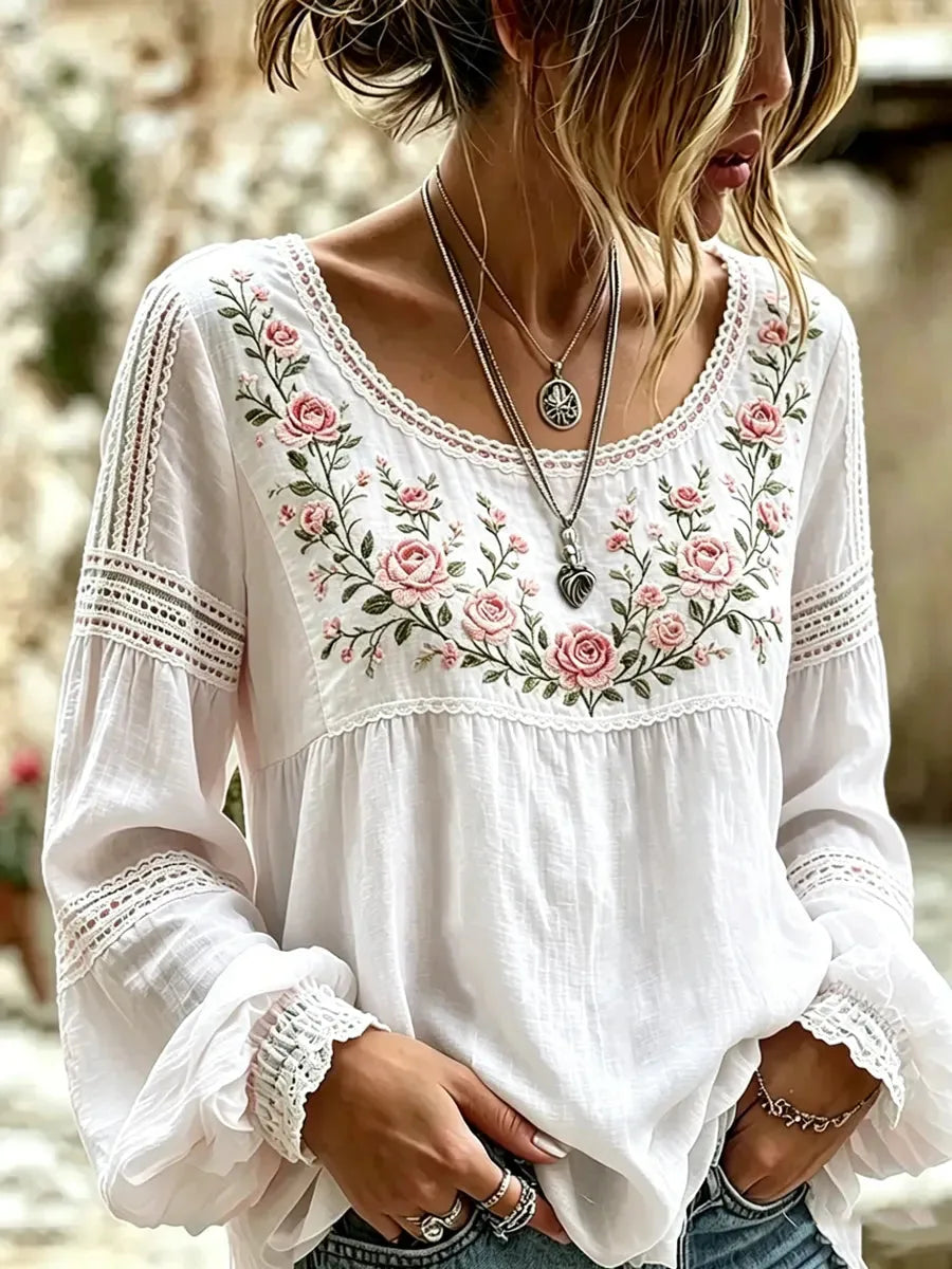White blouse with delicate lace trim and pink rose embroidery, worn with layered boho necklaces