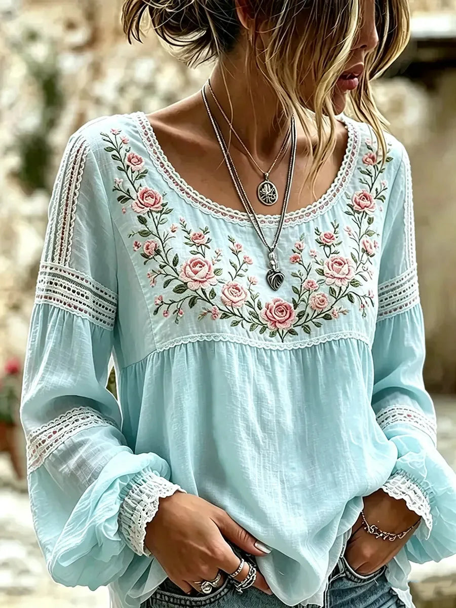 Model wearing the blouse with long bell sleeves, crochet lace inserts and a gathered babydoll hem
