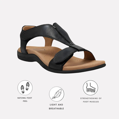 Black leather T-strap sandal with hook-and-loop closure and tan cushioned footbed, angled side view