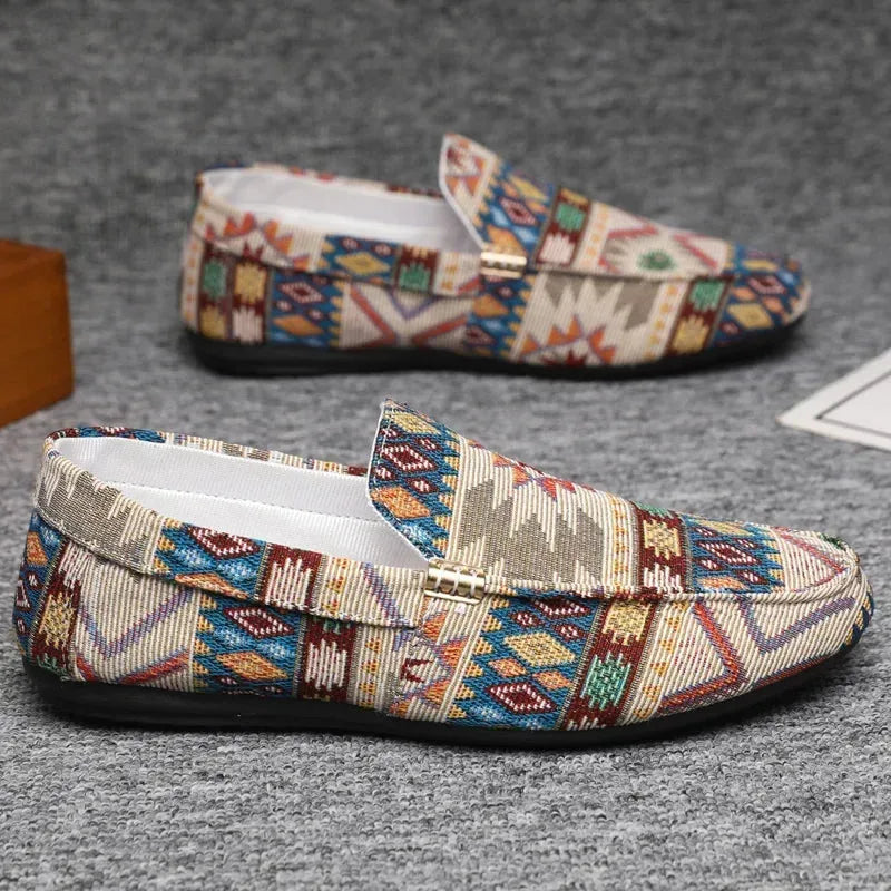 Side profile of two beige woven loafers with multicoloured Aztec-style jacquard pattern and flat black sole