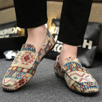 Side angle of a worn beige patterned loafer on foot, highlighting the gold saddle detail and slip-on fit