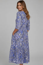 Back view of the blue floral midi dress showing the fit through the shoulders and flowing skirt