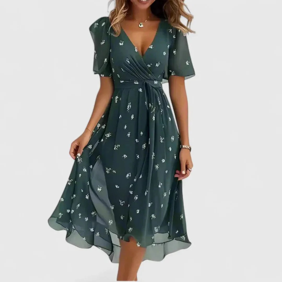 Model in deep green chiffon midi dress with small white floral print, V-neck and tie waist detail