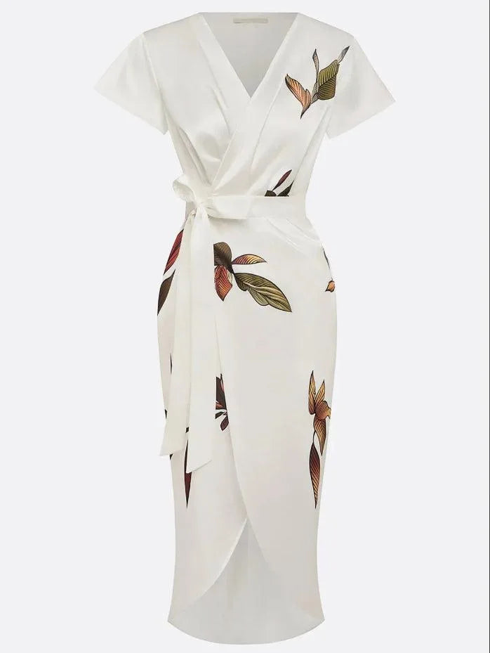Close-up of the tulip-style skirt hem with front slit, showing the leaf print on the ivory wrap midi dress