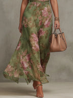 Close-up of the flowing chiffon maxi skirt in motion, showing the sheer floral print fabric and wrapped waist sash