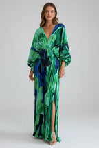 Front view of a model wearing a green and blue abstract print maxi dress with a deep V-neckline and balloon sleeves
