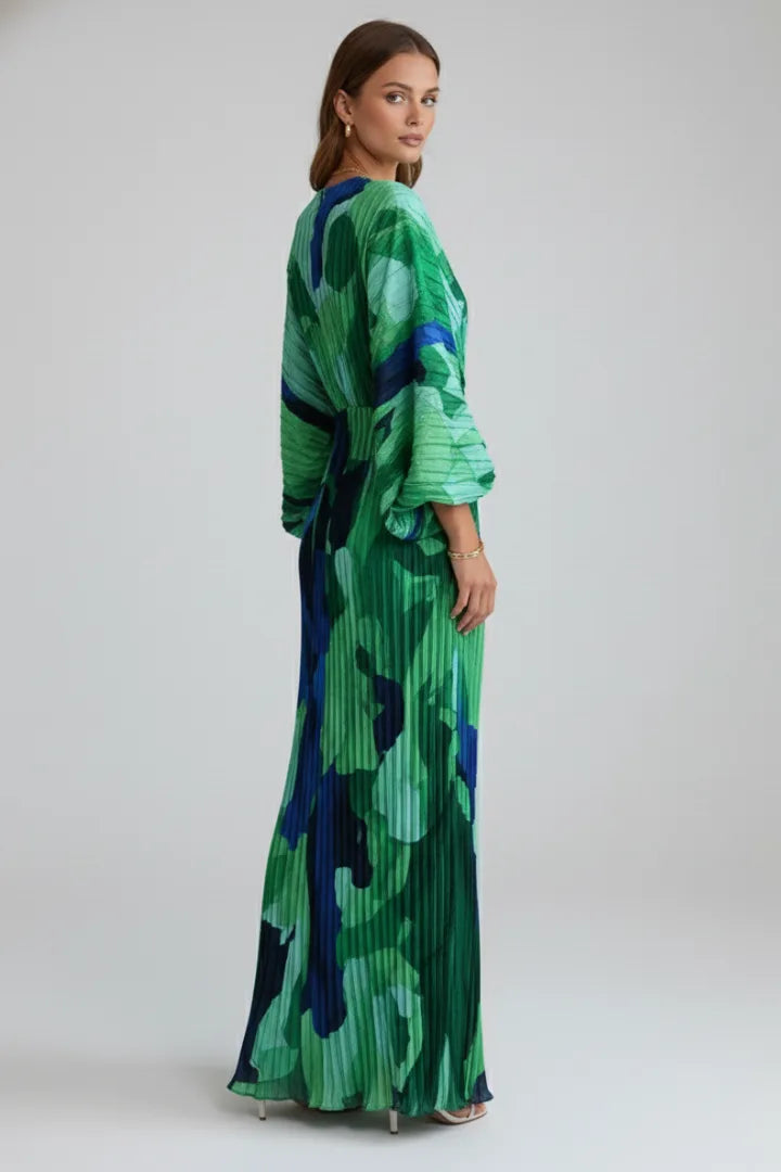 Back view of the model showing the pleated texture and gathered waist detail of the printed maxi dress