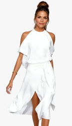 Front view of a woman wearing a white halter neck midi dress with cold shoulder sleeves and a draped wrap skirt