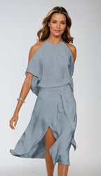 Front view of a woman wearing a soft grey satin-finish halter midi dress with cold shoulder sleeves and a front leg slit