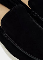 Macro detail of the suede texture and hand-stitched seam along the loafer's toe apron