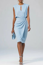 Model wears a pale blue sleeveless midi dress with keyhole neckline and gathered waist detail, paired with a matching clutch