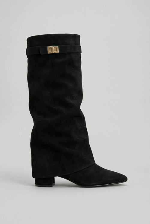 Side profile of a black suede-look knee-high boot with slouchy shaft, pointed toe and gold turn-lock buckle strap