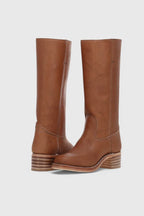 Front and side view of knee-high tan leather boots with stacked wooden block heel and round toe