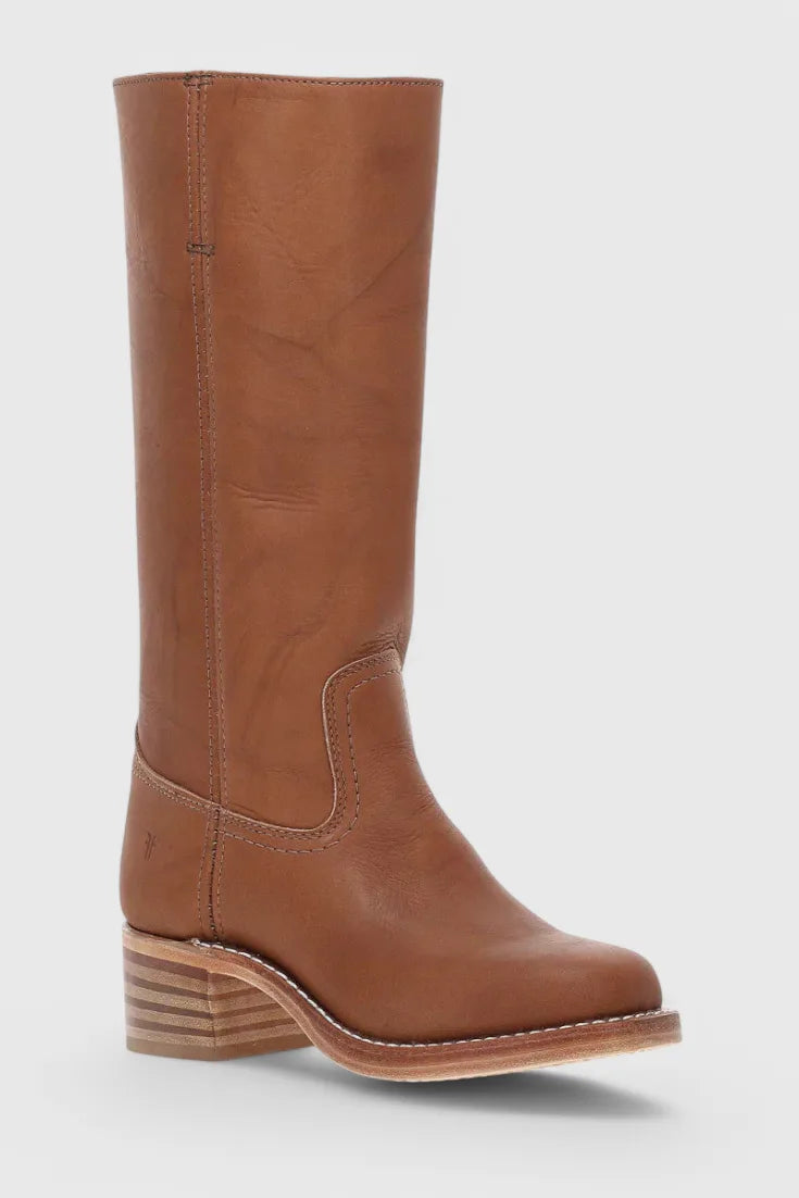 Side view close-up of tan leather boot heel and stacked sole construction on a plain background