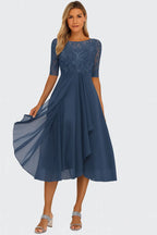 Slate blue midi dress with embroidered lace bodice, sheer sleeves and a flowing chiffon skirt with front drape