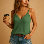 Model in green knit cami top holding a coffee cup, showing pointelle knit texture and lace neckline detail