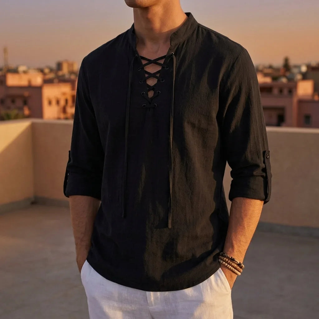 Man wearing a black lace-up Renaissance shirt with long sleeves on a rooftop at sunset